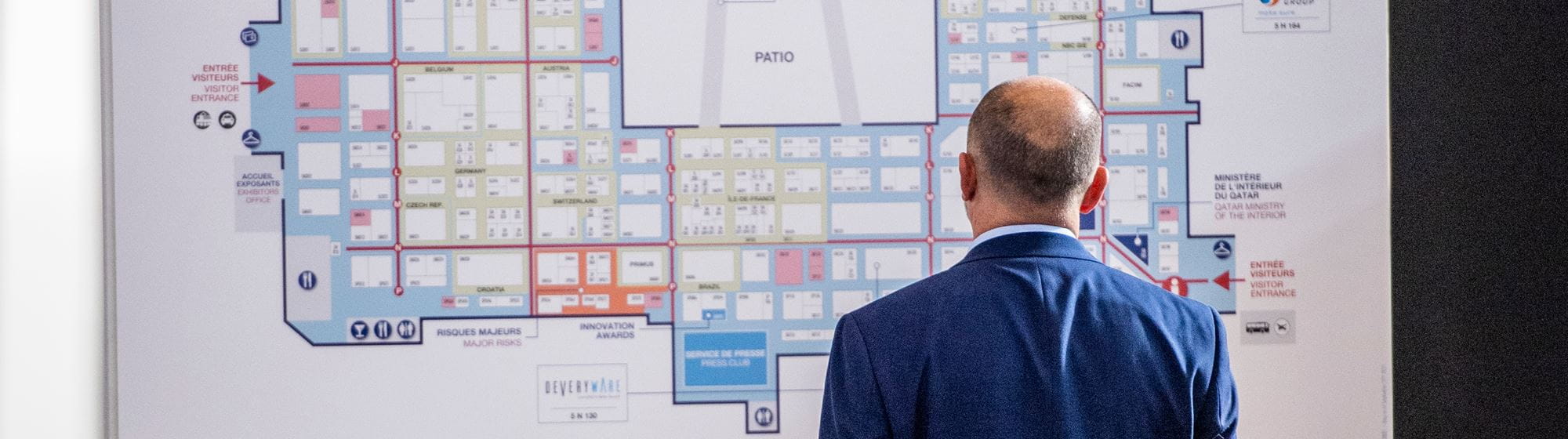 A visitor standing in front of a Milipol Paris floor plan