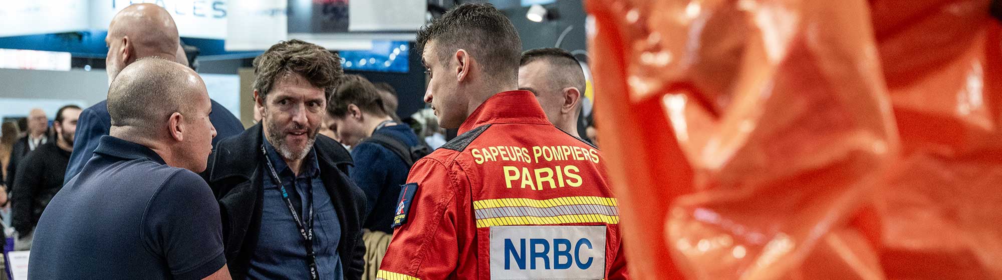 Discussion on the BSPP stand between a visitor and two firefighters in uniform