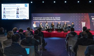 Conference on homeland security with experts on stage during Milipol Paris with a large audience.