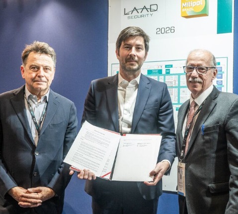 Les Directeurs de Civipol, Comexposium & LAAD Security en costume posant devant une affiche de Milipol Brazil 2026, tenant un accord de partenariat signé