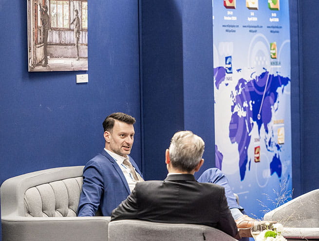 two men on business meetings in the VIP/official delegation area