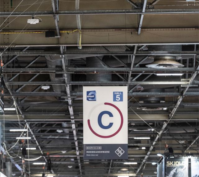 Signage with an exhibitor logo on an aisle letter at Milipol Paris.