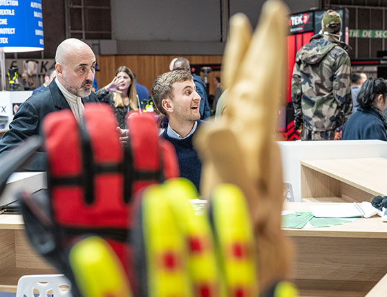 Exposant spécialisé dans les gants de protection souriant à quelqu'un