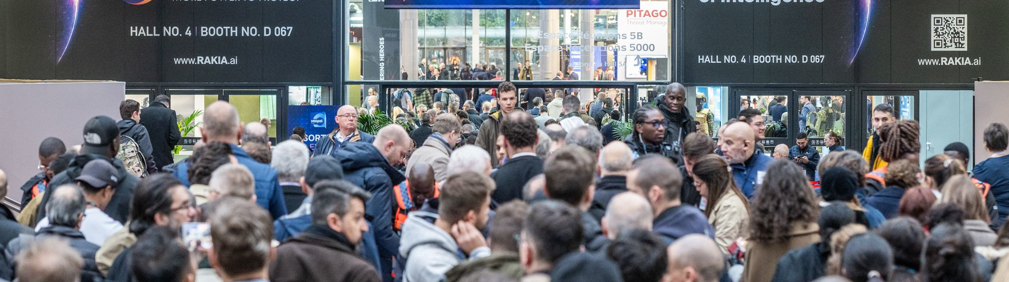Entrance to Hall 5 at Milipol Paris, with a large crowd of visitors and a sign asking to prepare ID.
